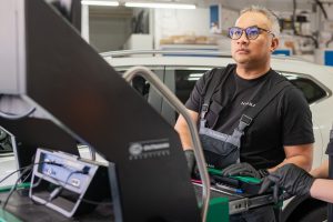 Ein Werkstattmitarbeiter kontrolliert die Daten des Fahrzeuges am Monitor.